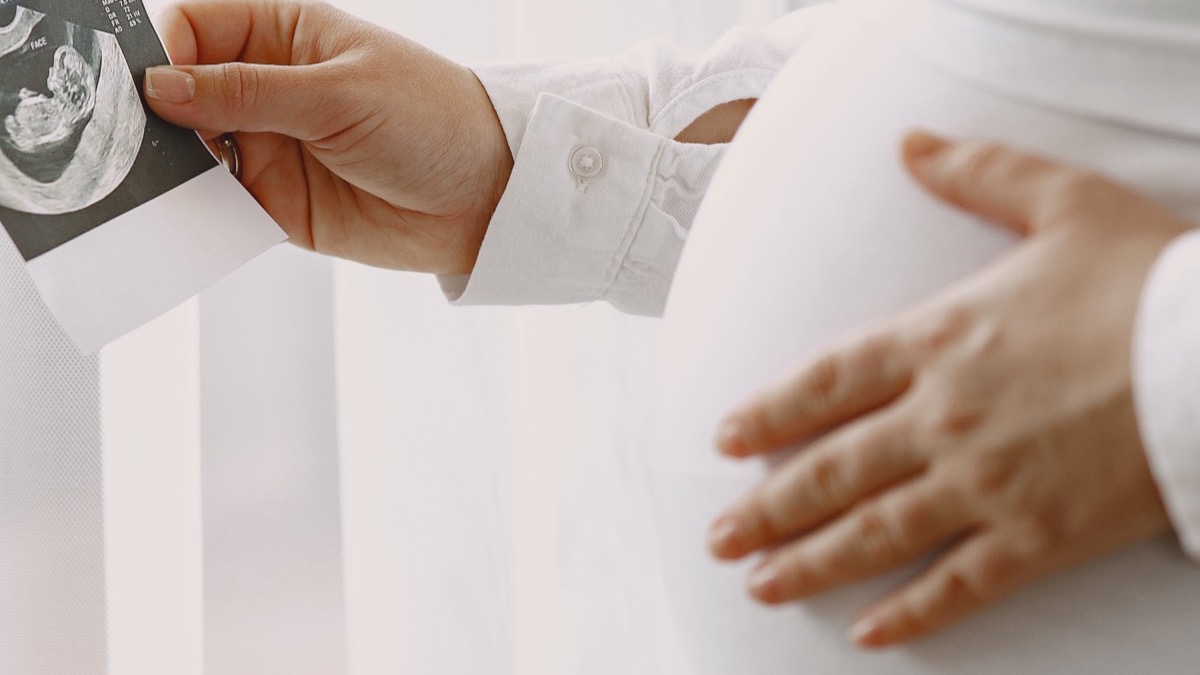 Parents' hands holding their newborn baby's feet